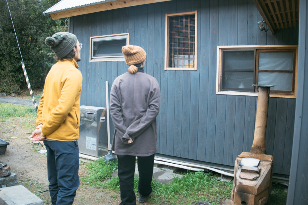 自分たちで作った家を見つめる二人